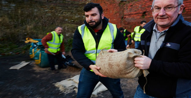 بريطانيا: اللاجئون السوريون يتطوعون للمساعدة لمواجهة آثار الفيضانات
