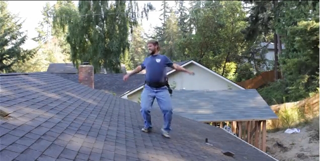 عامل بناء يستمتع بوقته أثناء إصلاح سقف أحد المنازل
