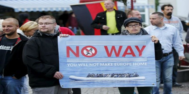 أنصار اليمين المتطرف في ألمانيا يحملون لافتة ضد اللاجئين