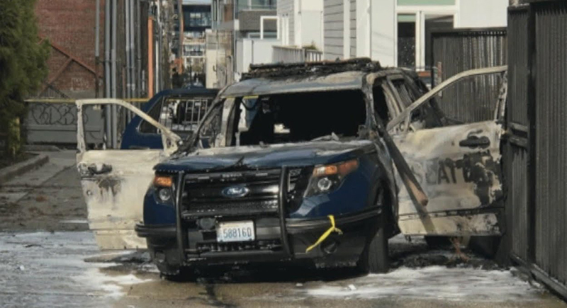 أمريكي يُلقي بشعلة نيران ملتهبة في سيارة شرطة والضابط بداخلها (فيديو)