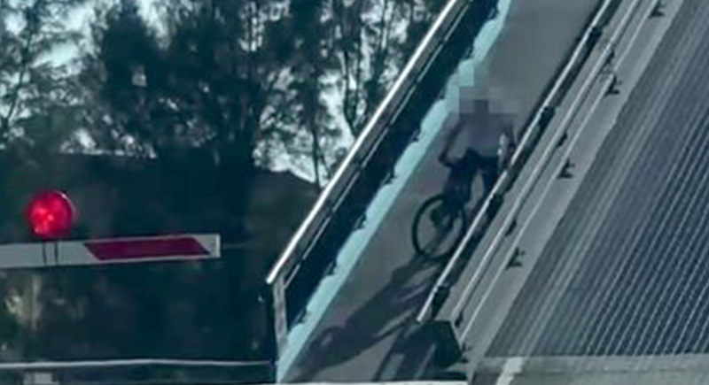 موقف حرج لراكب دراجة يمر فوق جسر لحظة فتحه وانقسامه إلى نصفين (فيديو)